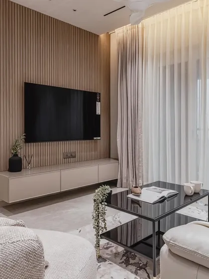 The living room is the heart of the home, and we design its focal point with precision. This modular TV unit features a European membrane finish, routed shutters for texture, and a dramatic fluted panel background. The back-painted glass top adds a layer of sleek, modern elegance, demonstrating our passion for combining diverse materials.