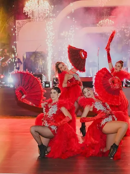 Dancers in vibrant red costumes performing with fans, bringing a touch of Moulin Rouge energy to the cocktail party.