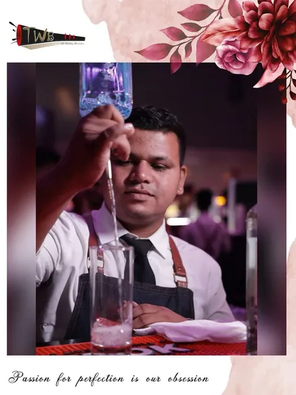 A bartender carefully pours a drink, demonstrating the focus and precision required for perfect mixology.