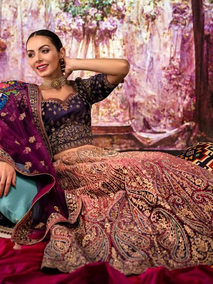 A luxurious, colorful room filled with pillows and textiles, created with projection. The setting adds a sense of opulence and comfort to this beautiful ethnic wear shot.