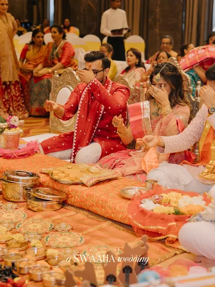The couple and their family participating in a traditional puja, a moment of prayer and blessing.