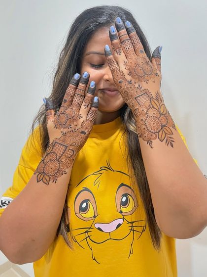 That's me, Miloni. Sometimes the artist needs some henna too. Here I am, showing off a design on my own hands.