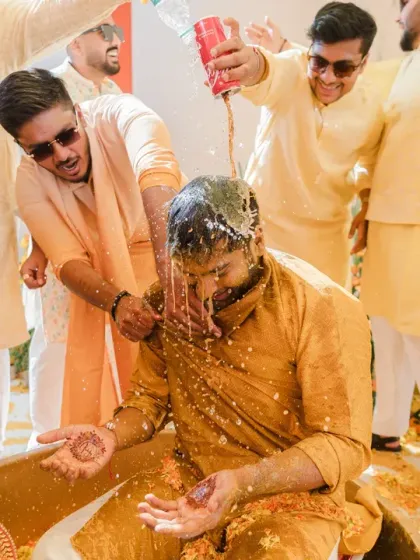 The groom gets a surprise drenching with a can of Coke during his Haldi. It's these hilarious, unscripted moments of madness that make for the best documentary wedding photos.