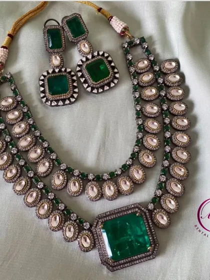 A grand Victorian set with a large emerald-green stone. This is a showstopper piece that is sure to turn heads.