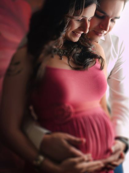 A soft-focus, intimate close-up of a couple embracing. This artistic shot emphasizes the emotional connection and tenderness between the partners during their pregnancy journey.