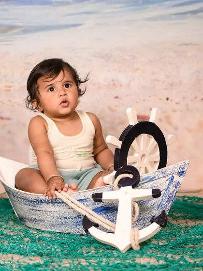 Explore our full nautical and beach-themed collection. These images showcase the variety of poses and angles possible with our boat prop, sand-colored flooring, and ocean backdrop.