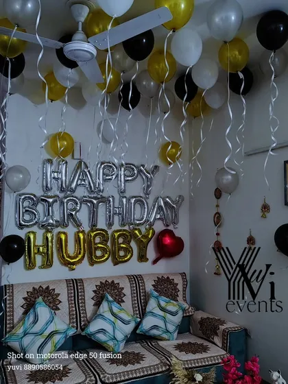 A fun surprise for a husband's birthday, this living room is decorated with black, gold, and white balloons. The 'HAPPY BIRTHDAY HUBBY' foil balloons make the message clear and personal.