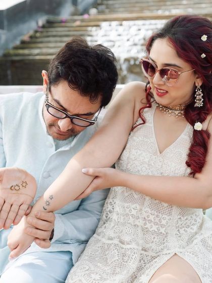 A fun, candid moment between the bride and her father, comparing their matching tattoos. It’s a personal, quirky detail that tells a unique story about their relationship.
