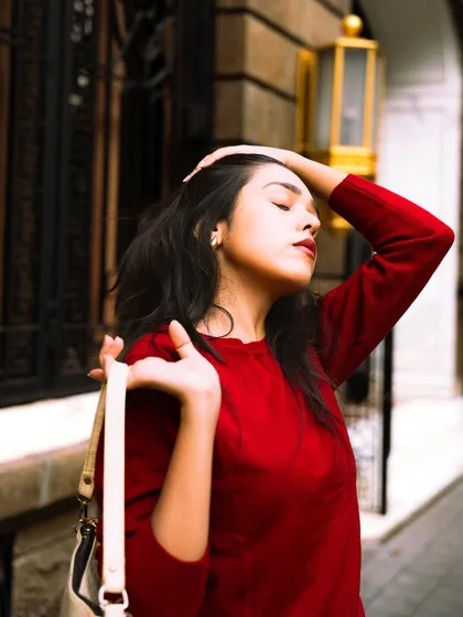 A candid, eyes-closed moment, as if soaking in the sun. This adds a touch of vulnerability and realism to the fashion shoot.