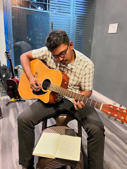 A student works through his lesson book during a guitar class. We combine practical playing with essential music theory to create well-rounded musicians.