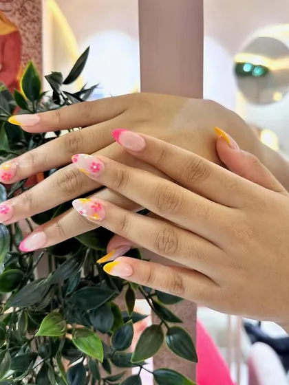 Summer-ready nails! This design combines a colorful French tip with delicate, hand-painted flowers for a fun and festive look.