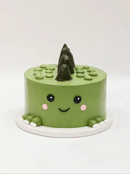 A cute and minimalist dinosaur cake, with a friendly dino face peeking out.