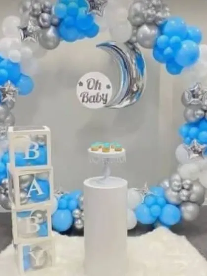 A classic "Oh Baby" shower theme in blue, white, and silver. This setup includes a balloon ring, a moon foil balloon, and "BABY" blocks, perfect for celebrating a baby boy.