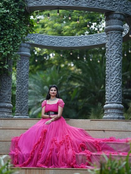 A regal solo portrait of a bride-to-be. The magenta ruffled gown with its long train is perfect for a grand and elegant pre-wedding shoot.