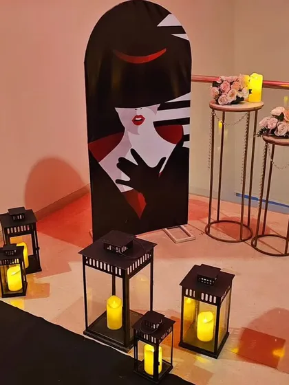 Decor elements for a diva-themed party, including a stylish cutout and candle-lit lanterns. These details help build a cohesive and immersive theme.