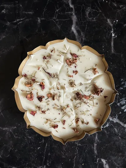 A beautiful top-down view of my copper urli floral candle. The dried rose petals and herbs sprinkled on top of the pure soy wax create a stunning visual and release a gentle fragrance when lit.