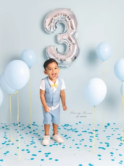 Another angle of this happy three-year-old enjoying his birthday celebration. The simple blue theme is classic and joyful.