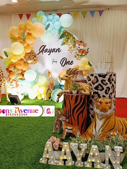 A full view of the jungle party stage, including the light-up name 'AAYAN' and the collection of animal props.