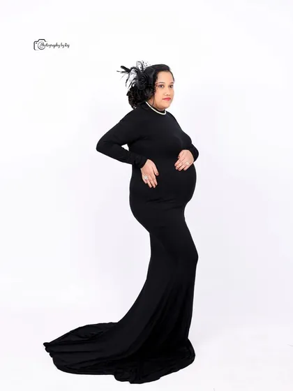 A classic silhouette portrait of a mother-to-be in a black gown, showcasing her beautiful baby bump.