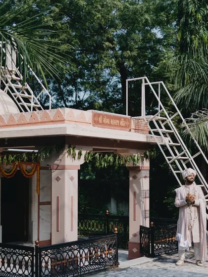A wide shot of the groom at the temple, showing the serene and traditional setting for the wedding.
