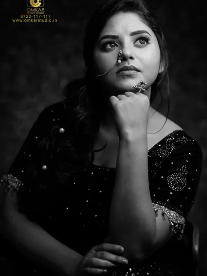 The same subject, captured in a classic black and white studio portrait. This style strips away color to focus on expression, form, and the texture of her embellished blouse, creating a timeless and dramatic headshot.