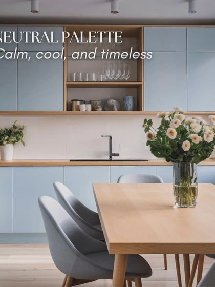 A neutral palette is calm, cool, and timeless. This kitchen uses a soft blue on the cabinets, paired with natural wood and a simple dining setup to create a welcoming and peaceful environment.