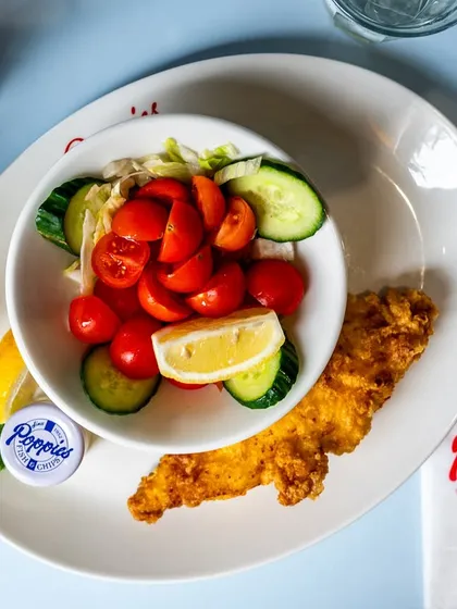 A classic British plate of fish and chips with a side salad. The overhead angle and clean plating make for a perfect menu photo.