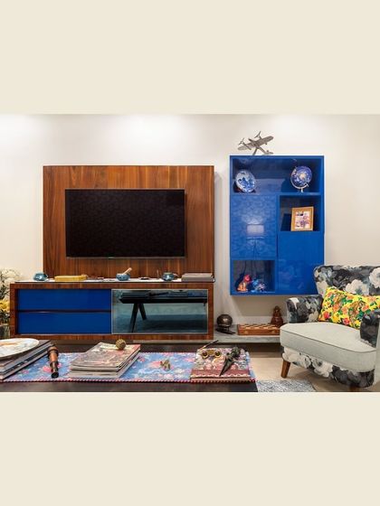 For a pop of excitement, this TV unit features a vibrant blue color and a mix of open and closed shelving. This approach keeps the look uncluttered while adding a bold, personal touch to the living space.