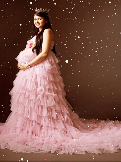 Celebrate your special journey with my maternity photoshoot gowns. This pink ruffled tail gown is perfect for creating those fairy-tale moments you will cherish forever.