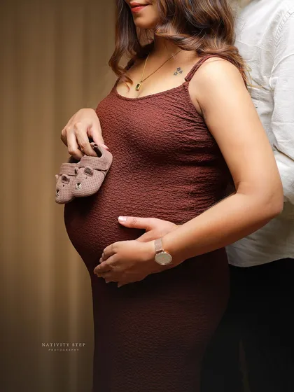 A close-up shot focusing on the baby bump and the tiny shoes. This is a classic and heartwarming way to announce your pregnancy.