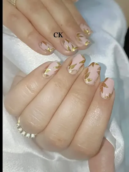 A simple and elegant design featuring a nude base with a hand-painted gold leaf pattern.