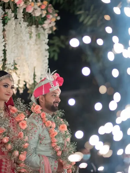 The couple stands for a ritual as cold pyro fireworks go off, adding a touch of modern celebration to the tradition.