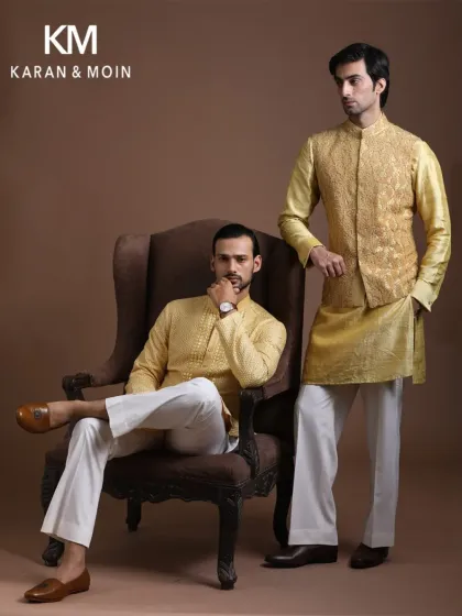 A proud reflection of culture and identity. This image showcases two coordinated looks in a regal gold hue, perfect for a wedding or grand celebration.