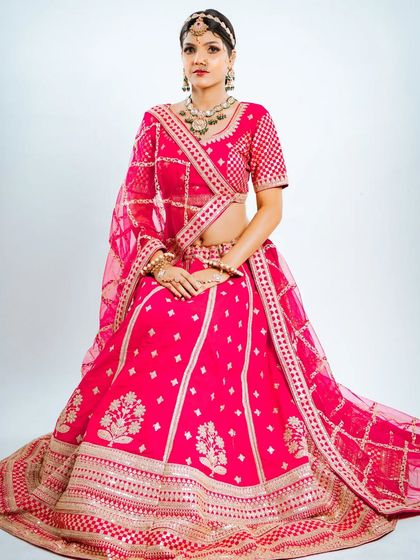 A seated pose that beautifully displays the full skirt of the lehenga and the richness of its fabric and embroidery.