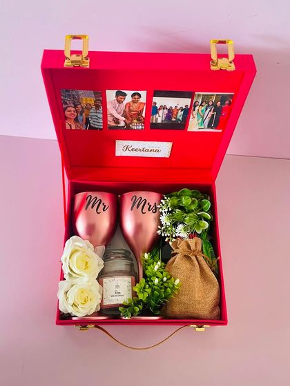A "Bride to be" hamper in a vibrant red suitcase box. I've included personalized "Mr & Mrs" glasses, a scented candle, and other goodies, with photos on the lid.