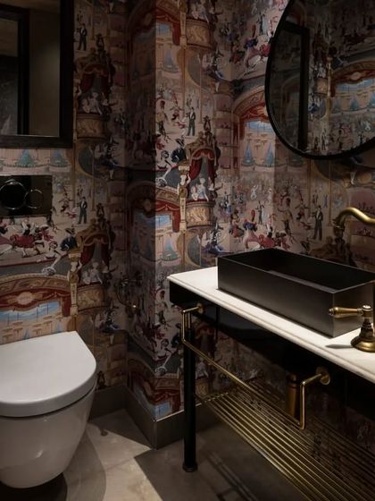 Another view of the captivating powder room, showing the custom vanity with a Michelangelo stone top and a solid brass basin. The round mirror and antique-style tap complete the look, blending classic luxury with bold, contemporary style.