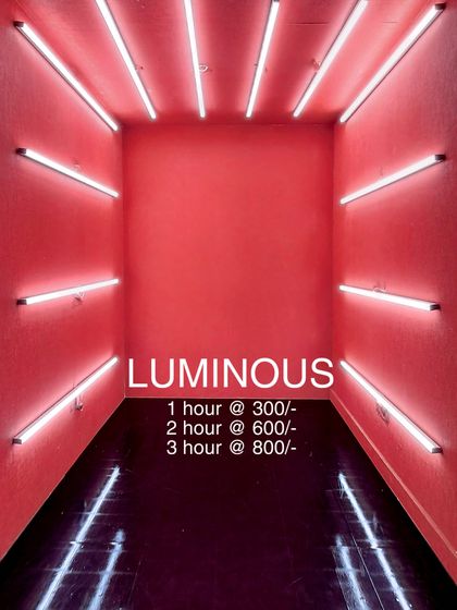 Welcome to the 'Luminous' booth. This room features vibrant pink walls and is framed by horizontal white tube lights on all sides, creating an immersive box of light. The rental prices are listed for this popular and eye-catching reel-making space.