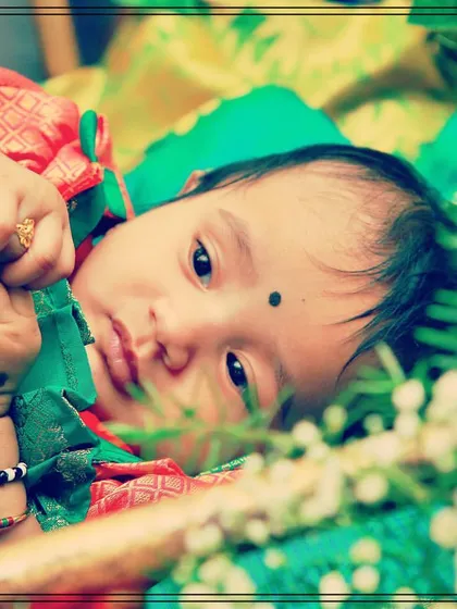 An adorable close-up of the baby resting peacefully in the decorated cradle during the naming ceremony.