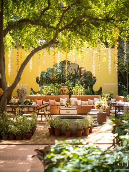 A wide view of a lounge area at the 'Kesar Sehar' Haldi, showing how we used layers of plants and furniture to create a lush, immersive garden feel.