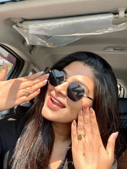 A joyful shot of a client highlighting her new nails. The natural finish and perfect shape give her hands a polished and elegant appearance.