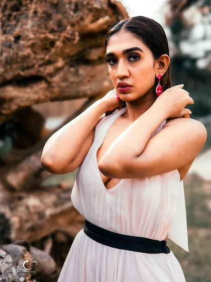 A powerful and confident portrait. The natural rock background adds a rugged texture that contrasts beautifully with her elegant gown.