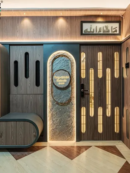 The entrance sets the tone for the entire home. For this Seawoods residence, we designed a custom foyer featuring a unique nameplate, integrated seating, and storage. The blend of wood textures, soft lighting, and geometric flooring creates a warm and impressive welcome.