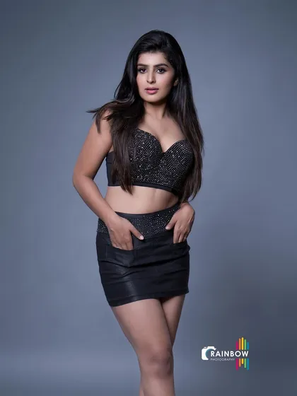A full-body shot in a black sequined outfit, conveying confidence and style.