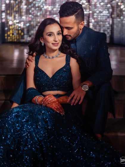 A classic, elegant portrait from a Sangeet night. The couple's coordinated navy blue outfits and the soft lighting create a sophisticated and romantic image that is simply timeless.