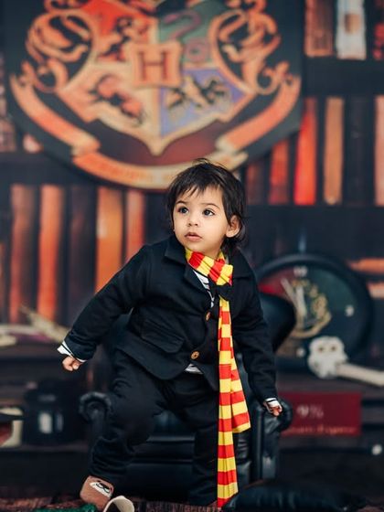 I don’t need a cape to be a superhero, I have my pajamas! A young wizard stands ready for adventure in front of the Hogwarts crest.