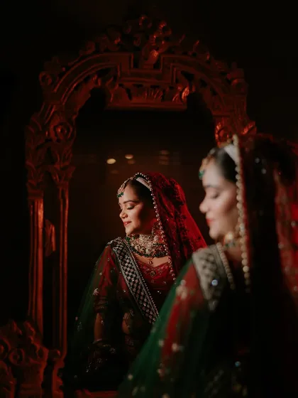 A quiet moment of reflection for the bride, Shikha, before the ceremonies begin. I love using creative lighting and reflections to create artistic bridal portraits that are full of emotion and beauty. This shot feels like a painting, capturing her serene confidence.