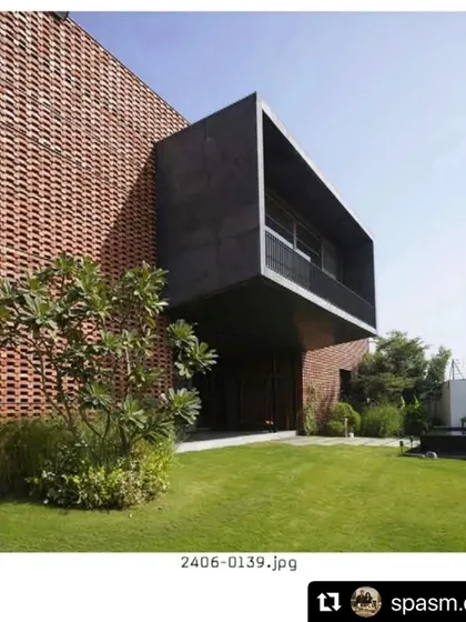 The Ishtika house seen from its garden. We designed a simple, open lawn to contrast with the complex, textured facade of the building, allowing the architecture to take center stage.