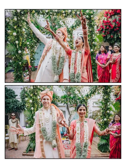 That "just married" feeling! The couple celebrates with excitement after their Jaimala ceremony, surrounded by a lush floral arch. Their energy is infectious, marking the start of their new life together.