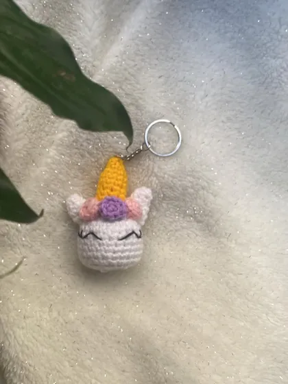 A custom-made unicorn head keychain. The horn is a bright, cheerful yellow, and it has a little flower in its mane. It's a small piece of magic you can carry with you.