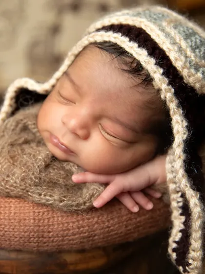 A close-up on the baby's sweet face, wearing a cozy knitted aviator hat. These detailed shots are perfect for capturing their tiny features.